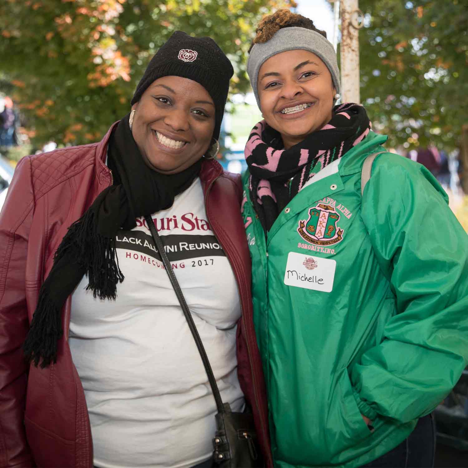 A Black alumni member and a current student at homecoming.