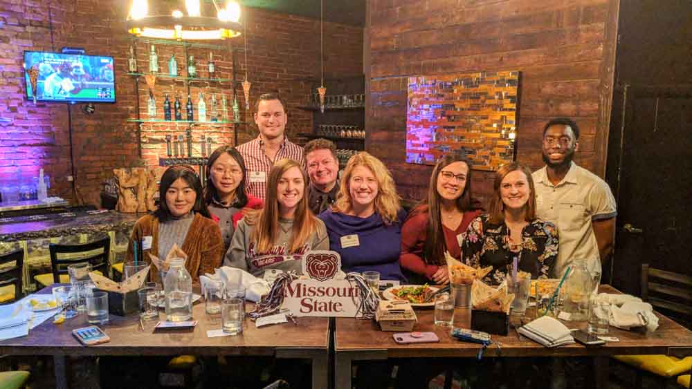 Alumnus Wade Kortaba and students at a Dinner with Eight Bears event.