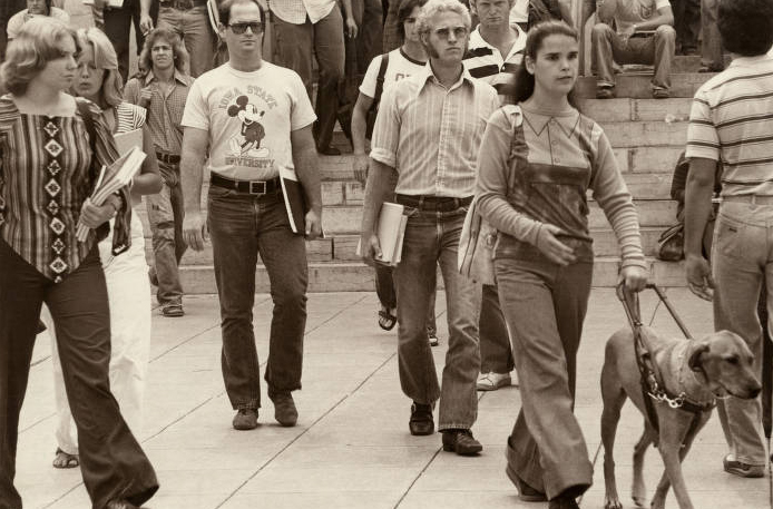 Black and white image of students exiting an academic building